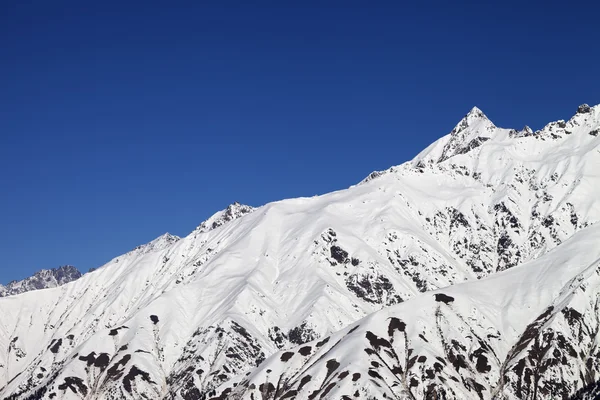 Snowy mountain peaks and blue clear sky