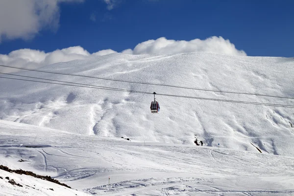 Gondola lift and ski slope at sun day