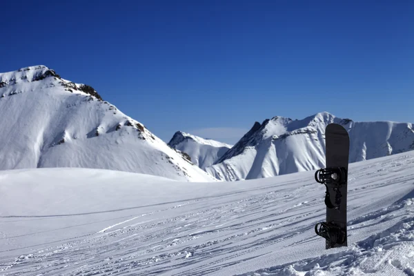 Snowboard in snow on off-piste slope