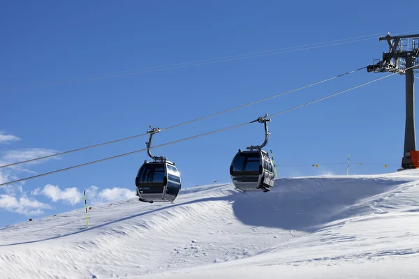 Gondola lift on ski resort at windy sun day