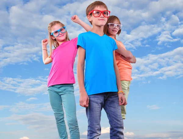 Group of happy friends wearing eyeglassesahainst blue sky