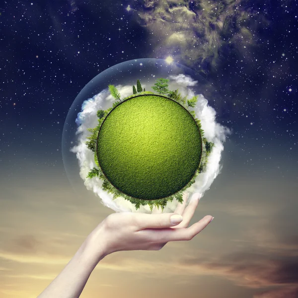 Green planet into human hand