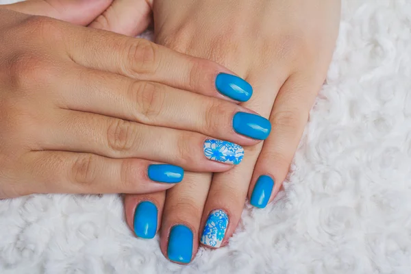 Light blue nail art with flowers on white textile