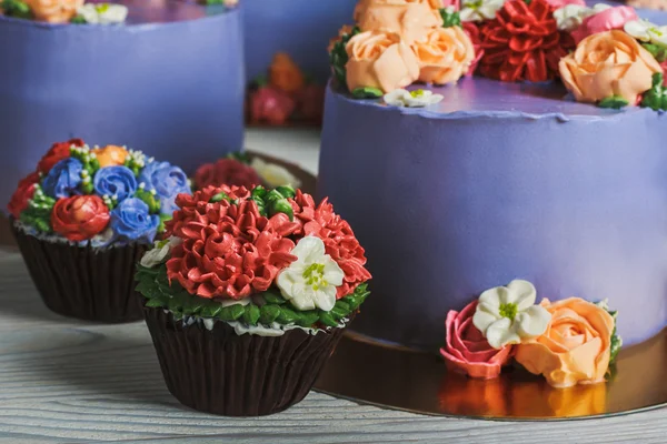 Purple cakes and muffins with cream flowers