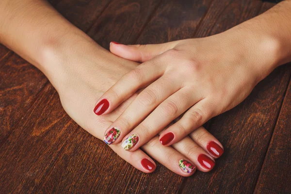 Red nail art with printed flowers