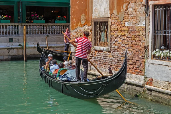 Gondolier rides gondola.