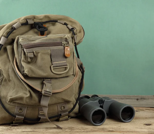 Old travel backpack and binoculars