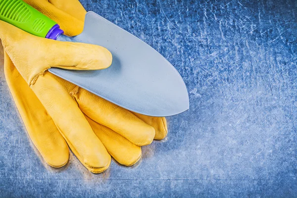 Yellow safety gloves and hand spade