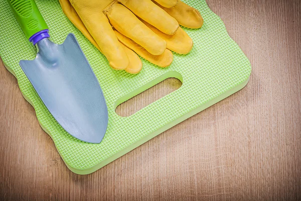 Protective gloves, kneeling pad and shovel