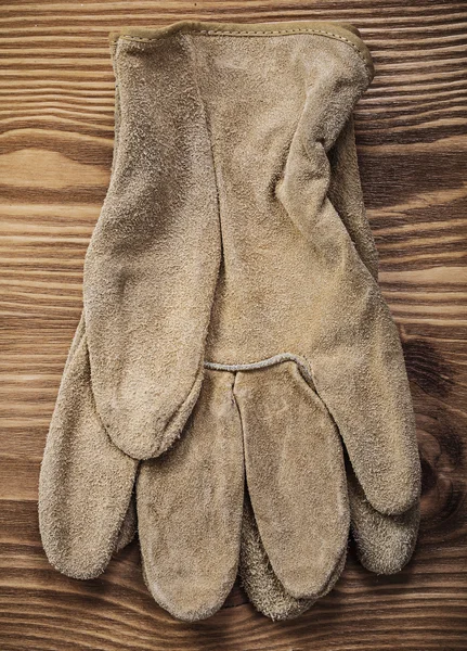 Leather safety gloves on vintage wooden board construction conce