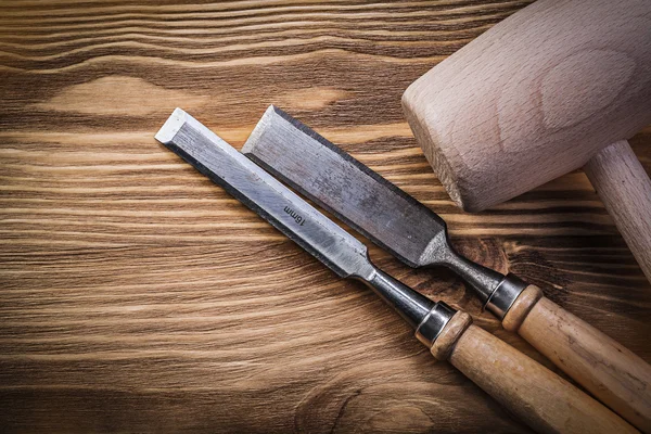 Wooden hammer chisels on vintage wood board construction concept
