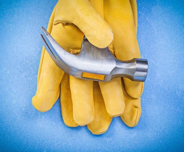 Composition of claw hammer protective gloves on blue background