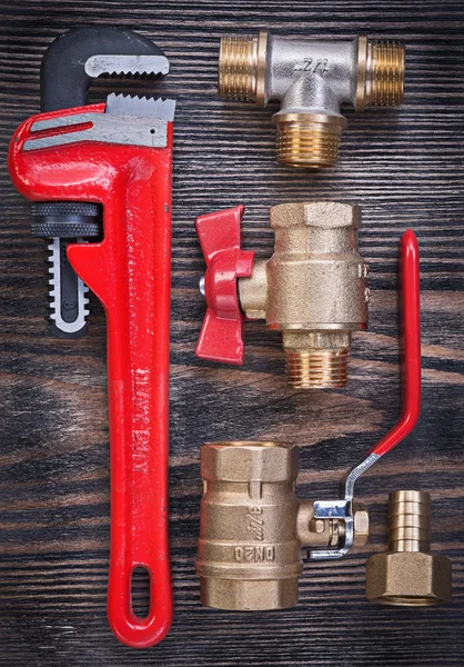 Composition of monkey wrench brass fittings water valve on woode