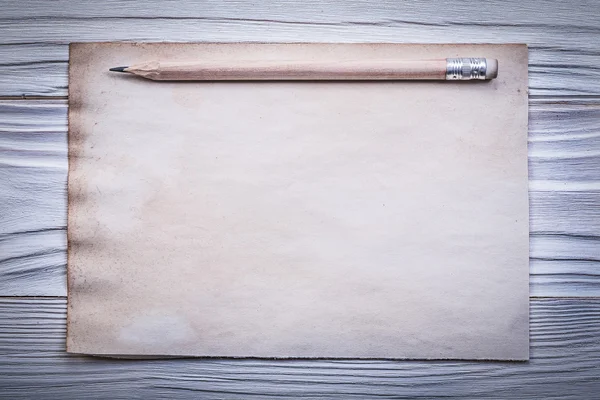 Vintage clean paper sheet pencil on wooden board directly above