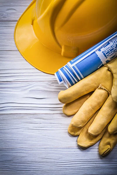 Safety gloves hard hat blue blueprints on wooden board construct