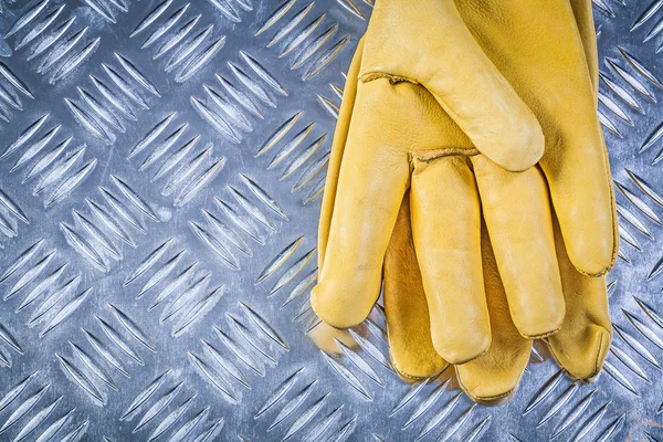 Leather protective gloves on corrugated metal plate construction