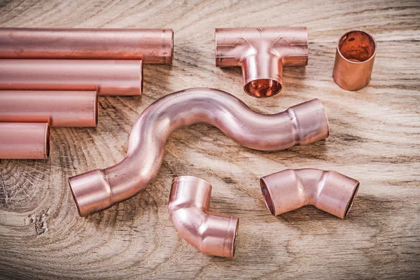 Brass water pipe fittings on wooden board plumbing concept