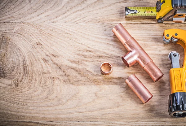 Copper water pipe cutter connectors tape line on wood board copy