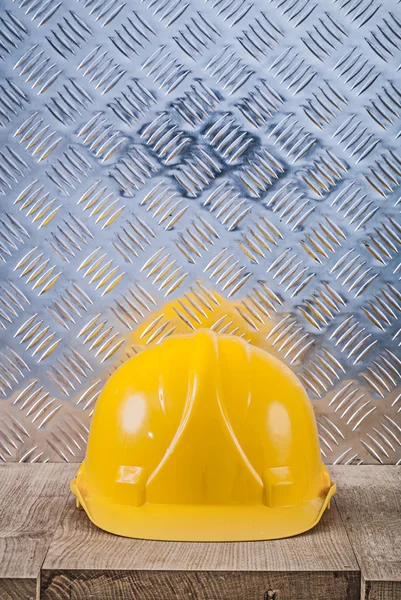 Yellow hard hat wooden board corrugated metal sheet