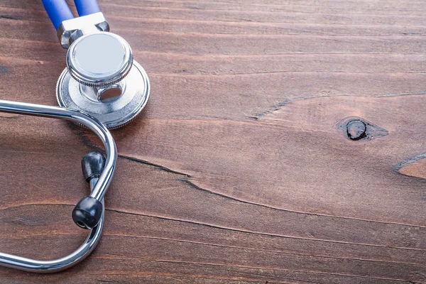 Medical stethoscope on vintage wooden board