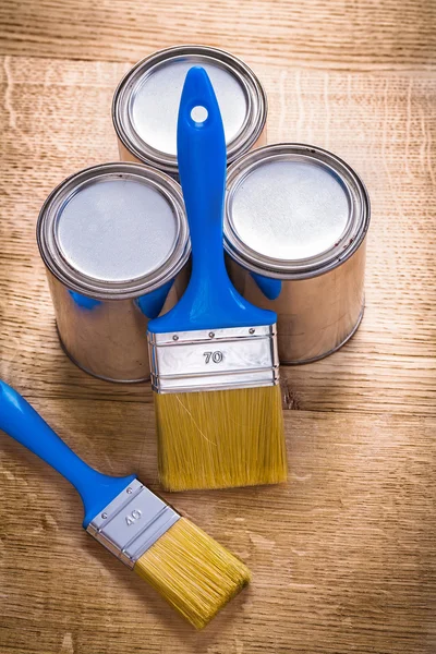 Two paint brushes and three cans