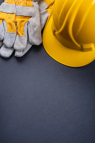 Protective work gloves and yellow helmet