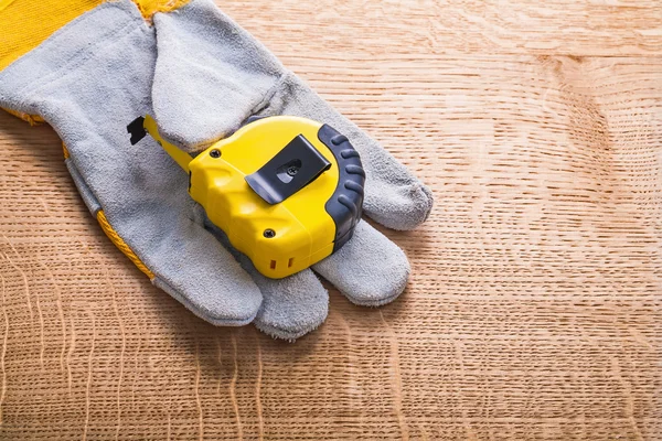 Construction tape measure on protective glove