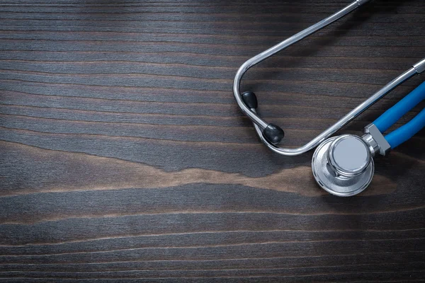 Wooden board with blue medical stethoscope
