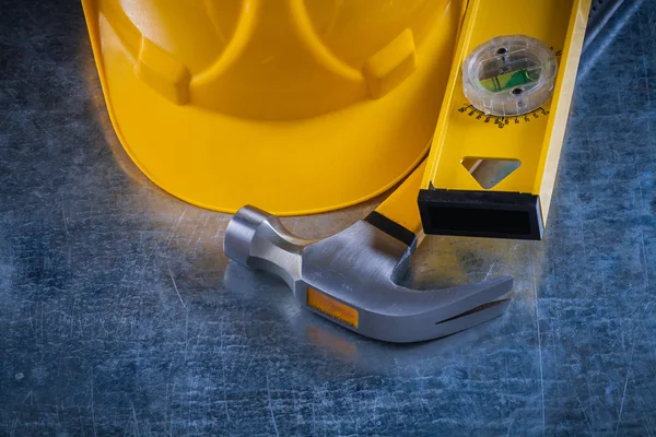 Hammer, construction level and building helmet