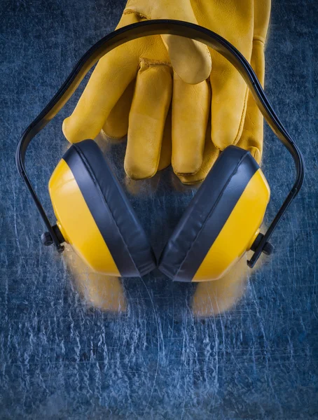 Headphones and leather safety gloves