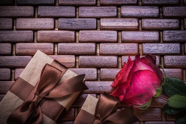 Red fragrant rose packed present box on wicker wooden mat