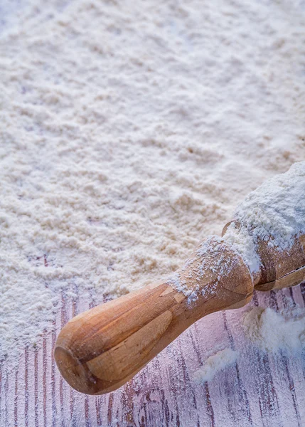 Rolling-pin with flour on wood