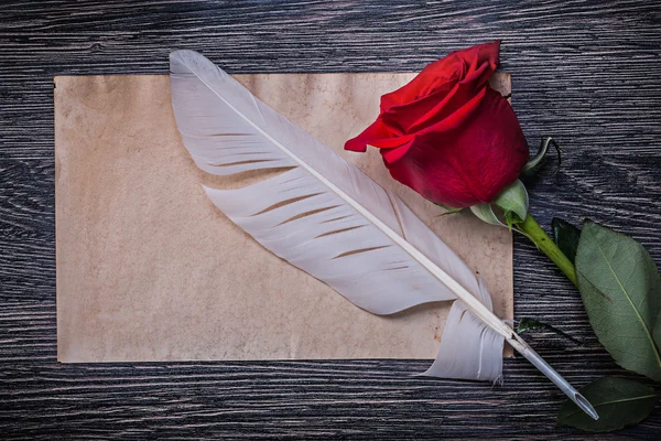 Paper, red rose and feather