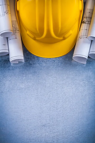 Blueprint rolls and yellow building helmet