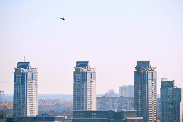 Helicopter flying above buildings.