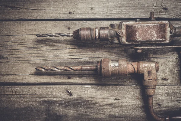 Retro hand drills on wooden table