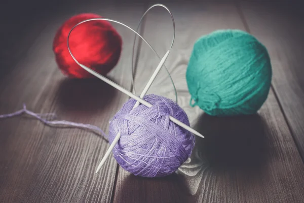 Knitting needles and balls of threads