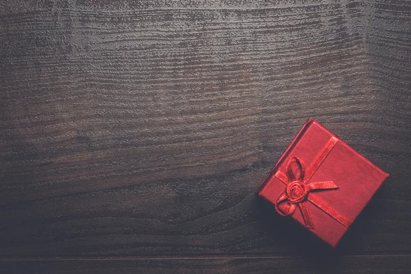 Red present box over wooden background