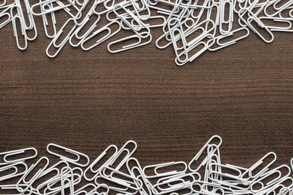 White paper clips on the wooden table