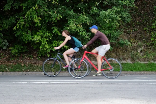 People on bikes ride in the park