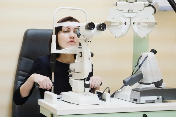 Woman looking into eye test machine