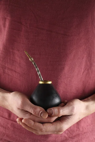 Hands macro holding mate to drink.