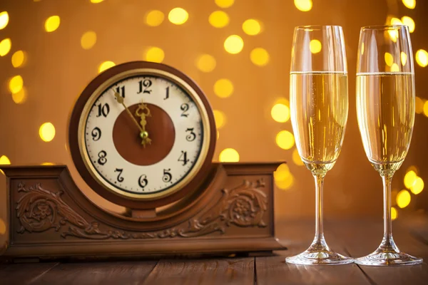 Glasses of champagne and ancient clock