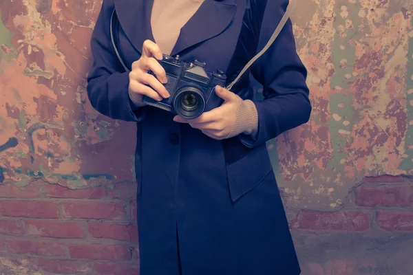 Girl with camera.Vintage times. Women holding retro photo camera outdoor.