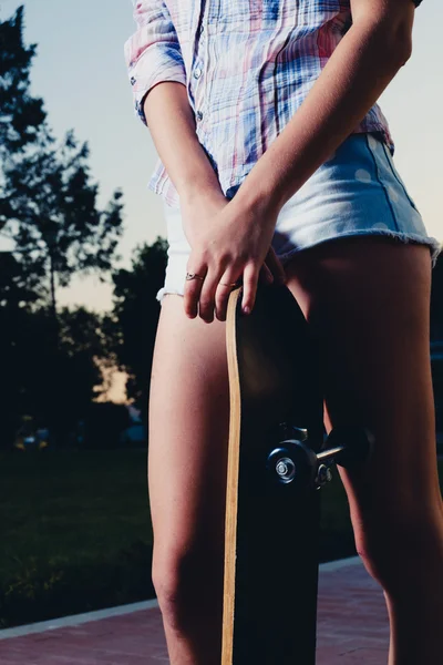 Low angle closeup of girl legs with skateboard