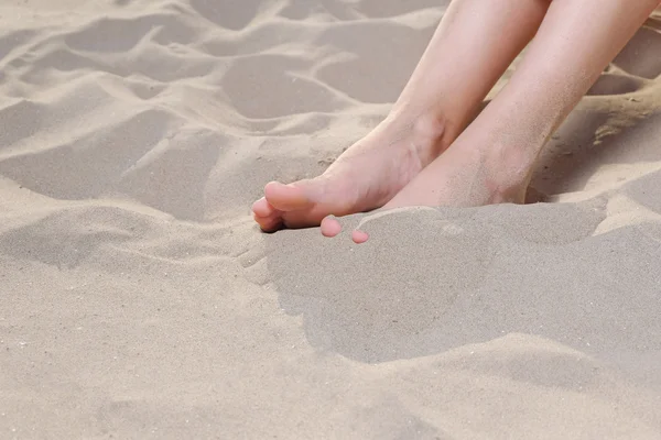 Woman sandy feet with natural nail on beach, copyspace