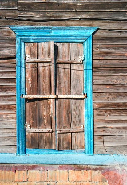 Traditional wooden house window with locked shatters in Astrakhan, Russia