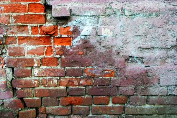 Red brick wall half covered with concrete, frame for design. Half painted wall. Concrete cracked wall grunge background