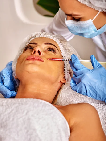 Woman middle-aged in spa salon with beautician. Female giving injections.