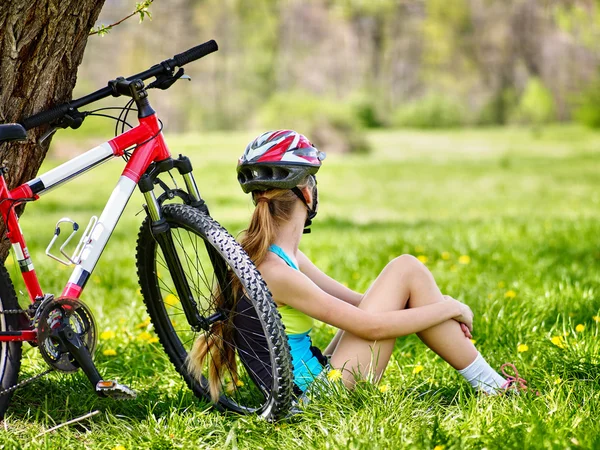 Bikes cycling girl wearing helmet. Girl in cycling sitting near bicycle.